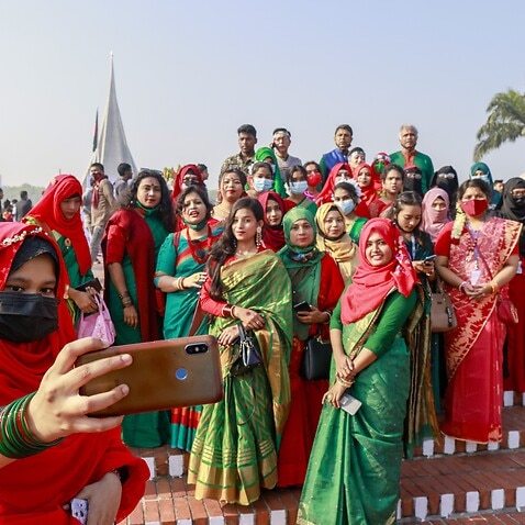 People take group selfie as they come to pay their respects at the 1971 independence war's martyrs national memorial to celebrate the 50th Victory Day.