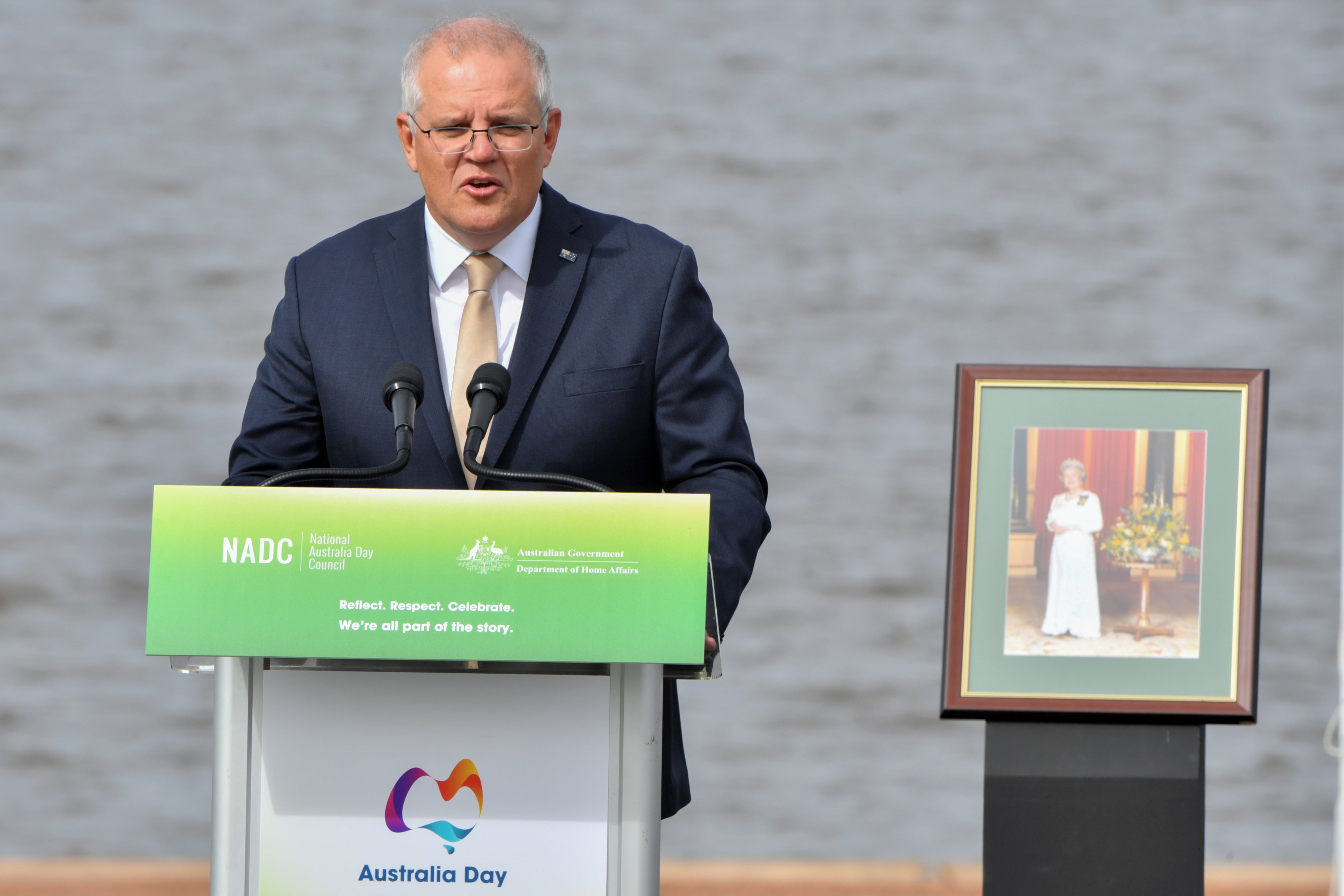 Prime Minister Scott Morrison with a portrait of Queen Elizabeth II during an Australia Day ceremony.