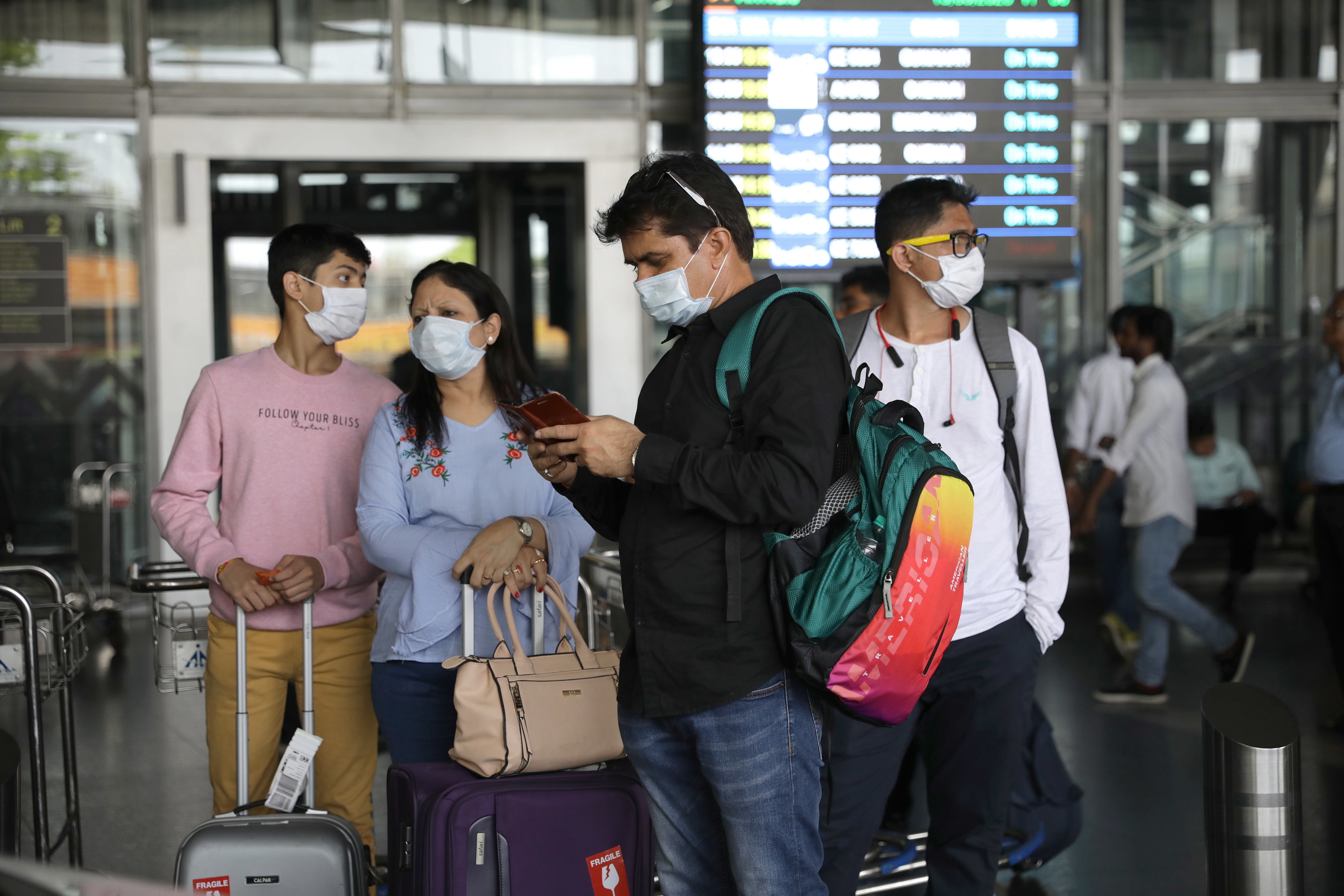 Passengers use protective masks at Netaji Subhash Chandra Bose International Airport in Kolkata, Eastern India, 13 March 2020.