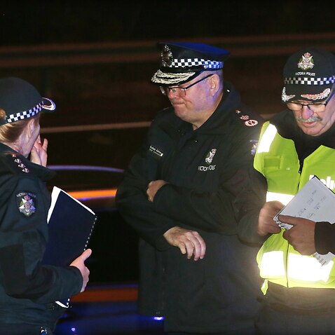 Victoria Police Chief Commissioner Graham Ashton (centre) is seen near where Emergency services responded to a collision in Melbourne.