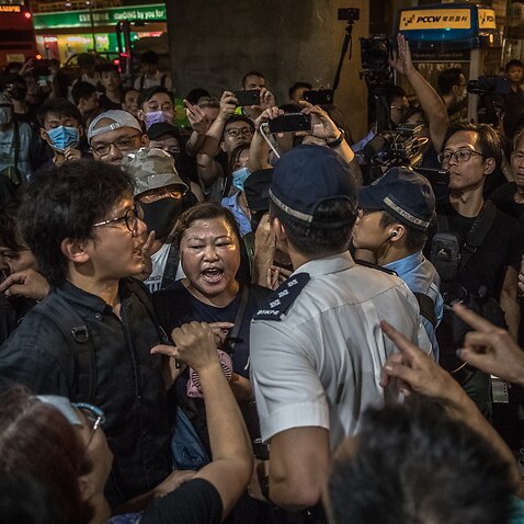 Protesters argue with the police outside a shopping mall during a rally to denounce recent firings at Hong Kong's airline Cathay Pacific.