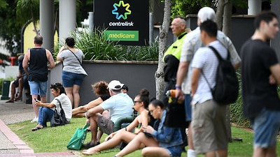 People are seen in long queues outside the Centrelink office in Southport on the Gold Coast, Monday, March 23, 2020.