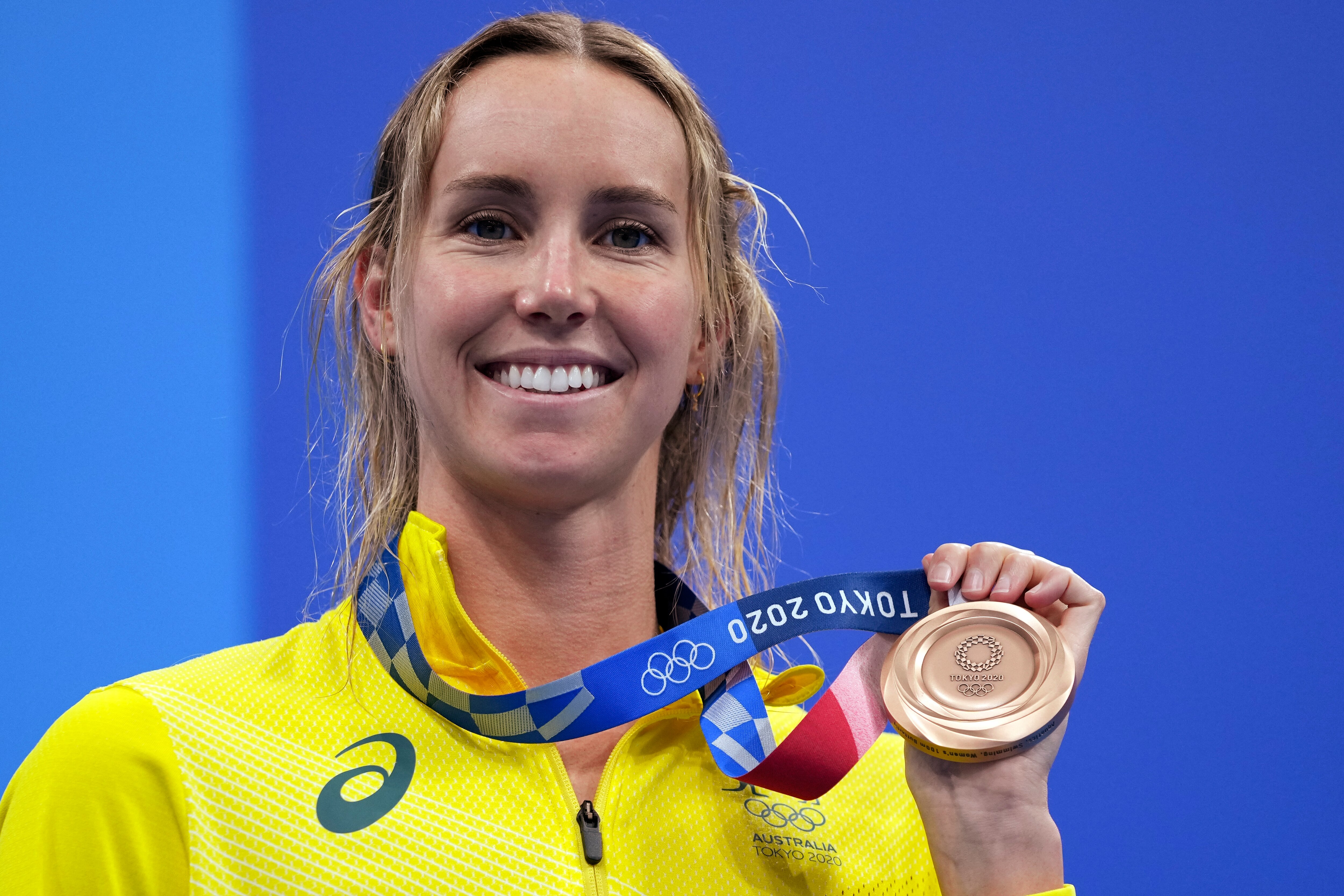 Emma McKeon of Australia holds her bronze medal on the podium after the final of the women's 100-meter butterfly at the 2020 Summer Olympics, Monday, July 26, 2021, in Tokyo, Japan. (AP Photo/Matthias Schrader)