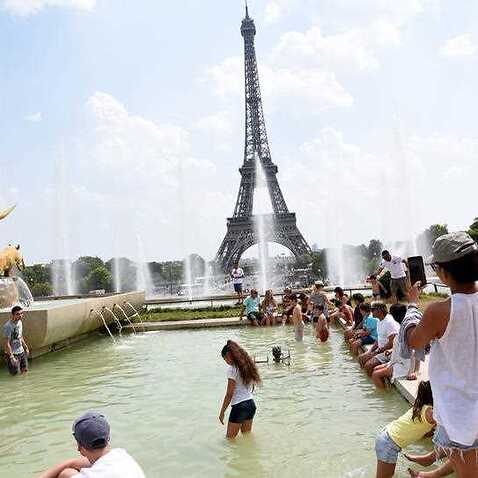 People cool down at the Fontaine du Trocadero in front of The Eiffel Tower in Paris, France, on July 26, 2018, as the French capital is placed on heatwave alert as temperatures are set to soar in the coming days.