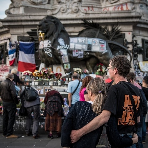 People pay tribute to the victims of the truck attack in Nice at the makeshift memorial site on Place de la Republique after the Paris attacks, in Paris