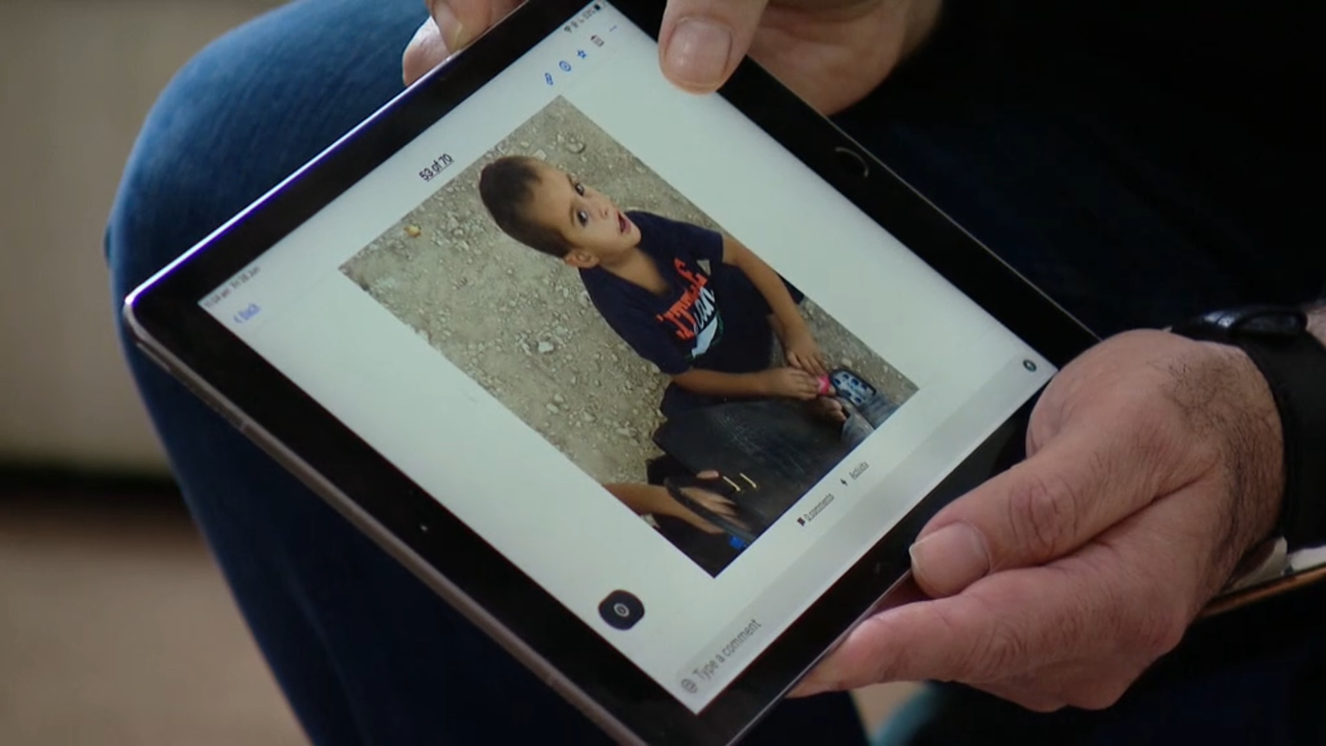 Kamalle Dabboussy looks at pictures of one of his grandchildren 
