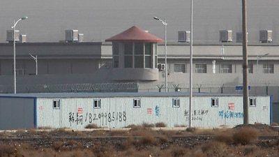 A guard tower and barbed wire fences are seen around a facility in the Kunshan Industrial Park in Artux in western China's Xinjiang region in 2018.