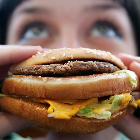 Woman thinks about eating hamburger 