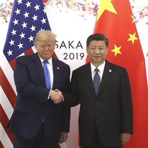 Chinese President Xi Jinping (R) shakes hands with US President Donald Trump.