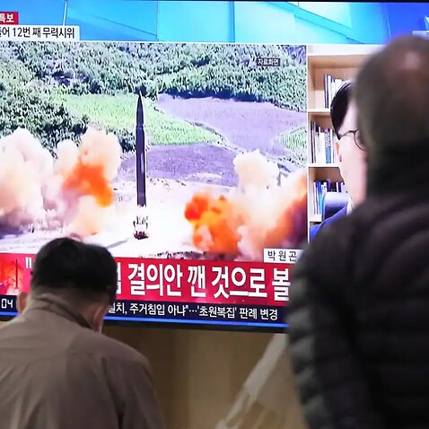 People watch a TV showing a file image of North Korea's missile launch during a news program at the Seoul Railway Station on Thursday, 24 March, 2022.