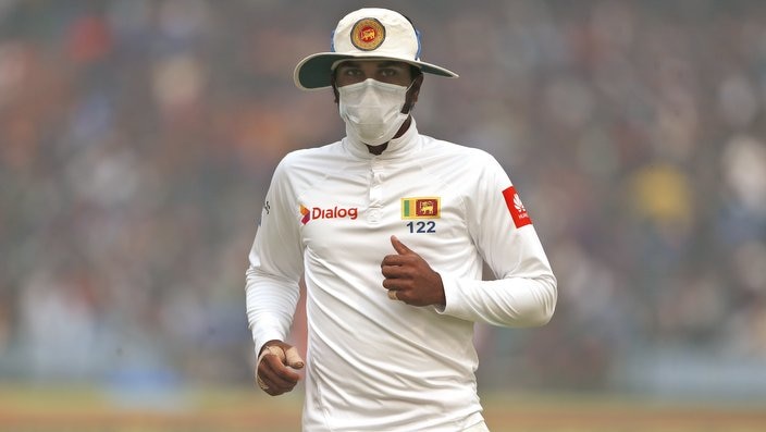 Sri Lanka's captain Dinesh Chandimal fields wearing an anti-pollution mask during the second day of their third test cricket match against India in New Delhi, India, Sunday, Dec. 3, 2017. (AP Photo/Altaf Qadri)