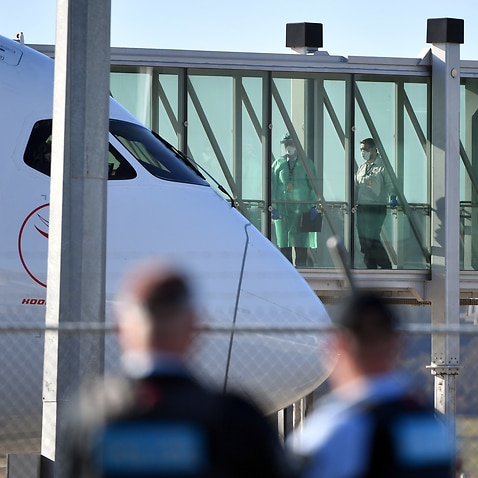 Health officials wait for Australians stranded in India to disembark a Qantas plane at Canberra Airport in May.