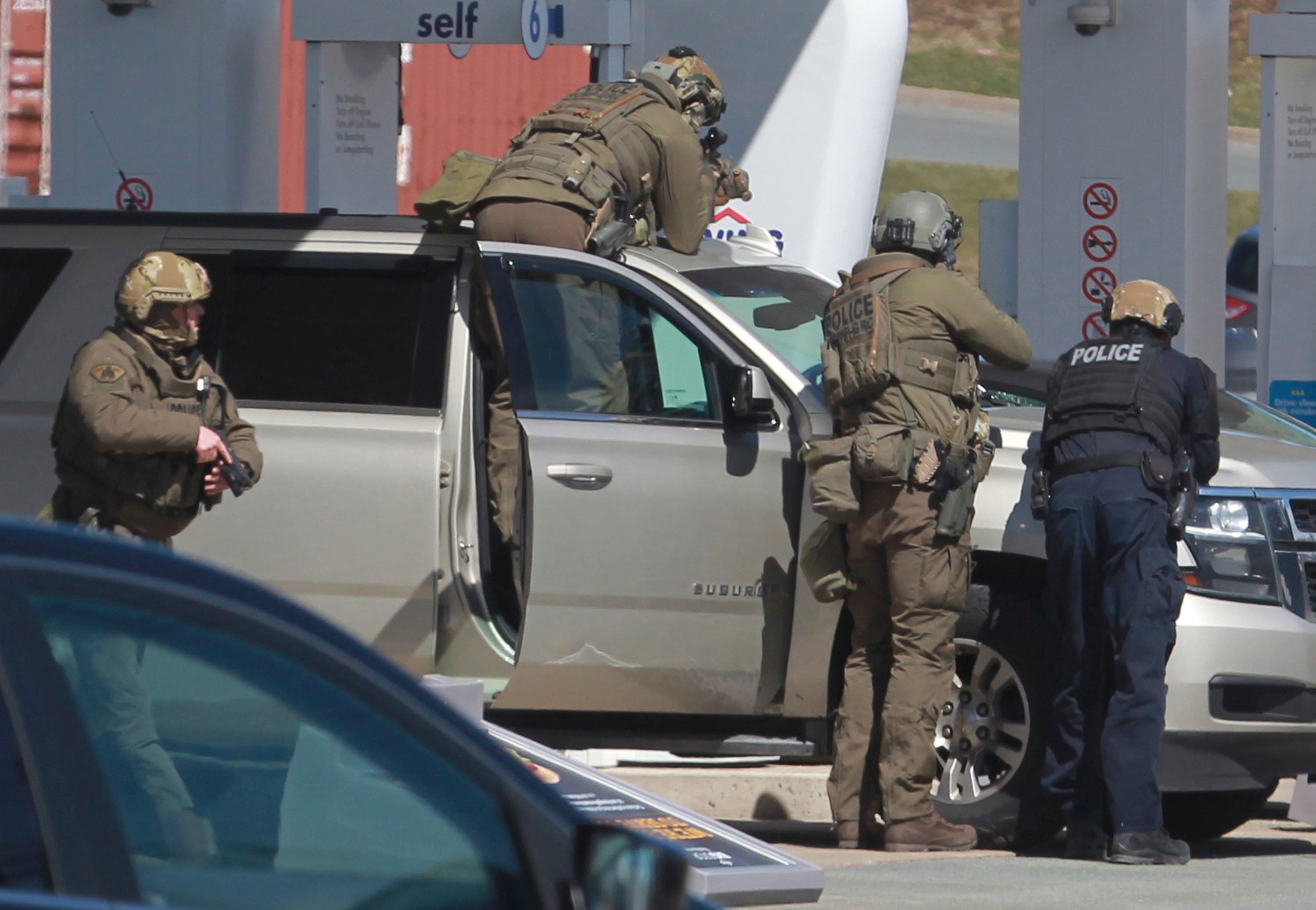 يستعد ضباط الشرطة لاحتجاز مشتبه فيه في محطة بنزين في إنفيلد ، نوفا سكوشا.