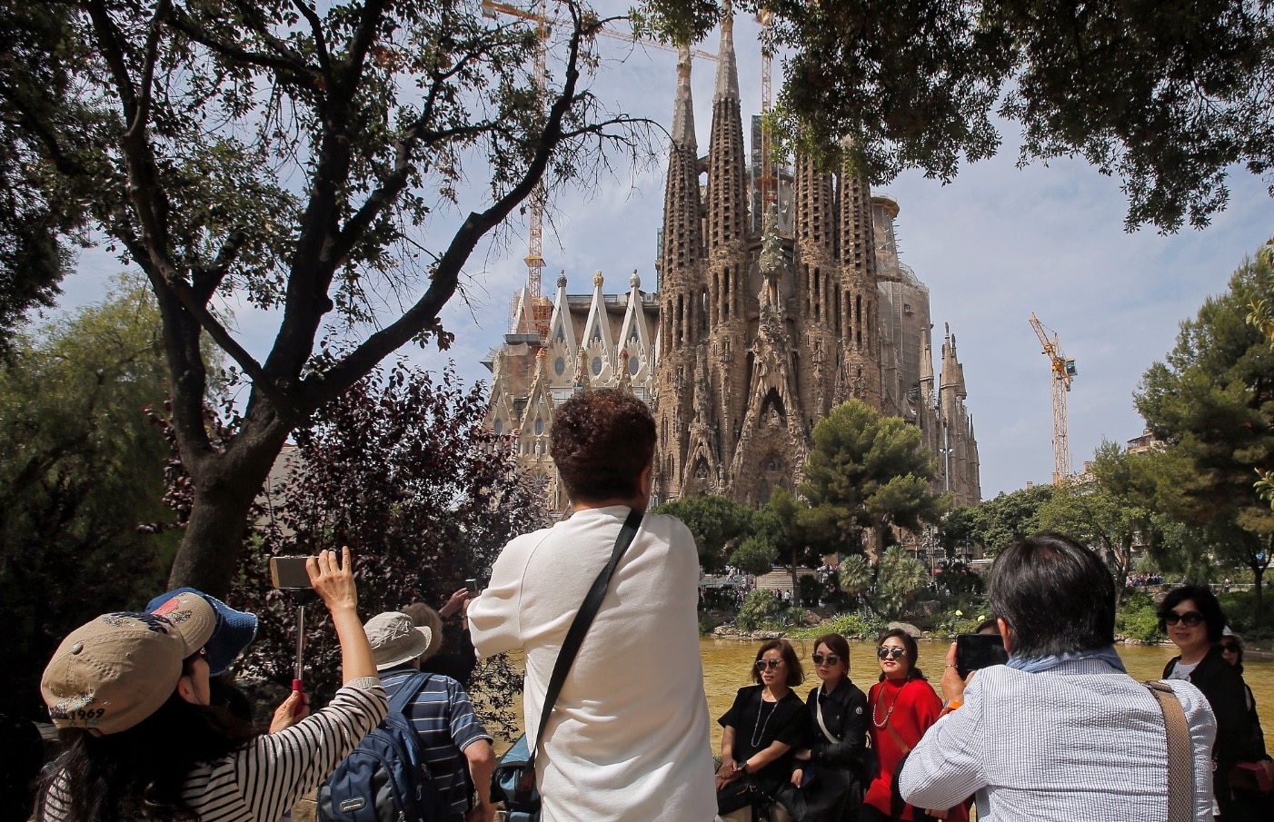 File: Tourists take pictures in front of Sagrada Familia church, designed by architect Antoni Gaudi in Barcelona.