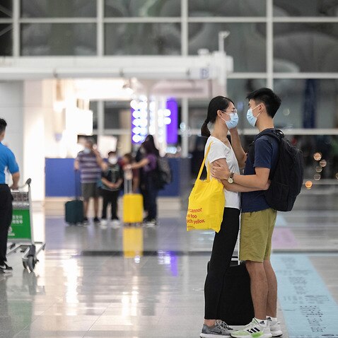 A man says farewell to his girlfriend before departure, at Hong Kong international airport a day before the deadline of 