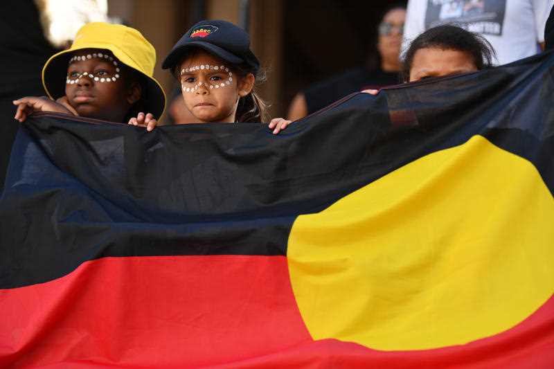 Children hold the Aboriginal Flag at a Black Deaths in Custody Rally at Town Hall in Sydney on 10 April 2021.