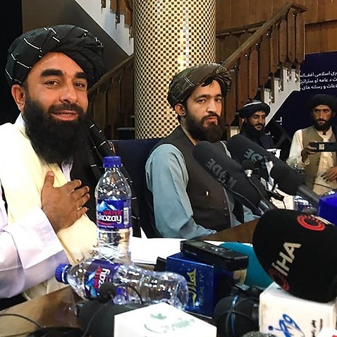 Taliban spokesperson Zabihullah Mujahid (L) attends the first press conference in Kabul on August 17, 2021, following their stunning takeover of Afghanistan. (Photo by Hoshang HASHIMI / AFP) (Photo by HOSHANG HASHIMI/AFP via Getty Images)