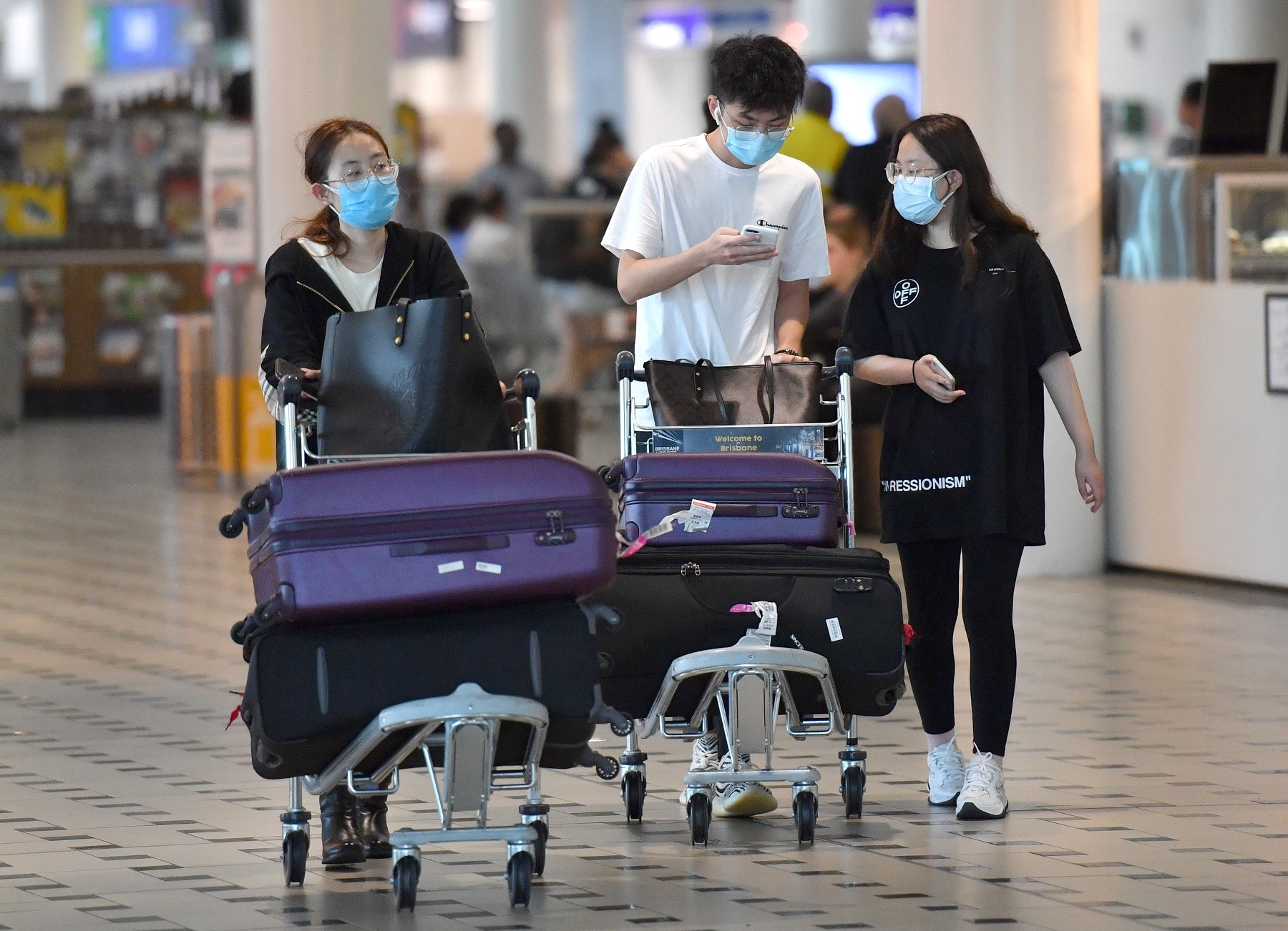 People wearing protective face masks at Brisbane International Airport.