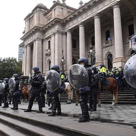 Riot police are seen outside the Victoria’s Parliament House during a protest by Construction, Forestry, Maritime, Mining and Energy Union (CFMEU) members in Melbourne, Tuesday, September 21, 2021.