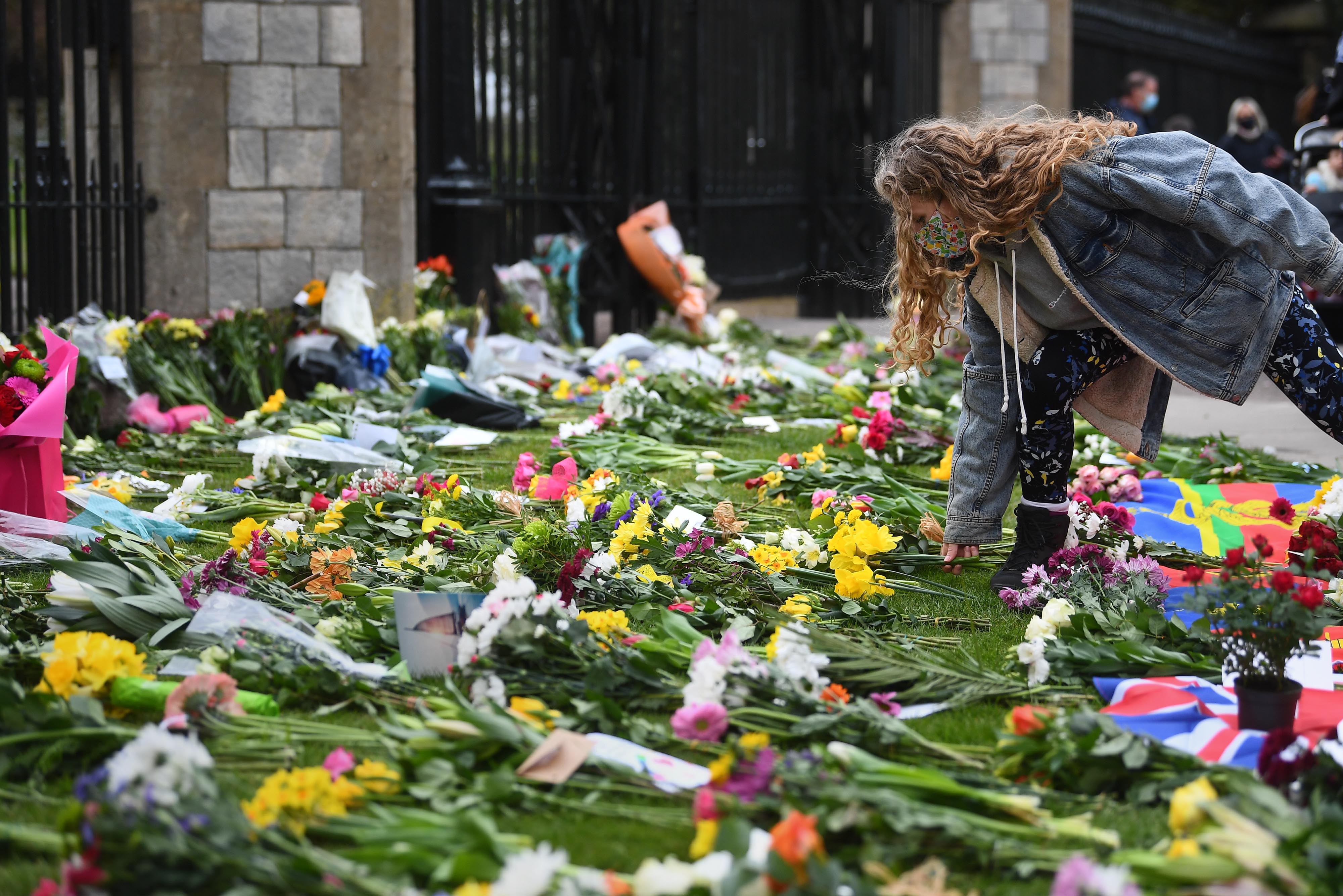A woman lays flowers at Cambridge Gate at Windsor Castle, Berkshire, following the announcement of the death of Prince Philip on 9 April, 2021.