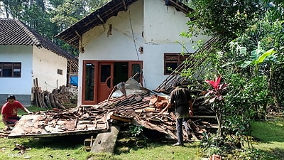 People inspect a collapsed house following a 6.0 magnitude earthquake that hit in Blitar, East Java, Indonesia, 10 April 2021. 