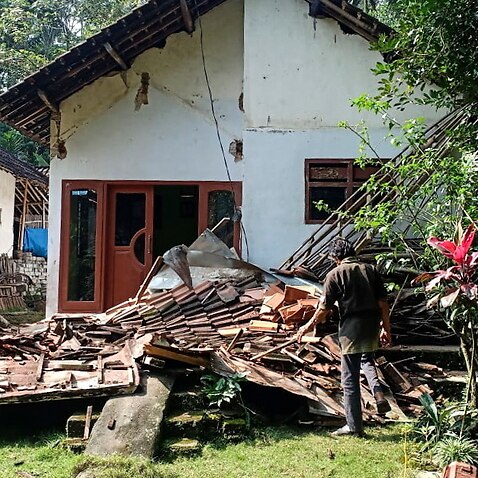 People inspect a collapsed house following a 6.0 magnitude earthquake that hit in Blitar, East Java, Indonesia, 10 April 2021.  