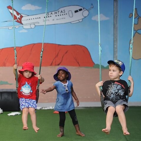 Children playing on swings at a childcare centre in Brisbane
