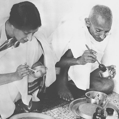 Mahatma Gandhi, right, sits down to share a meal with a guest in his home in India on May 22, 1936.  (AP Photo)