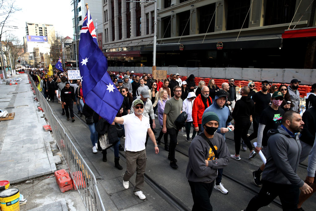 Unmasked protesters march down George St in Sydney, Australia. 