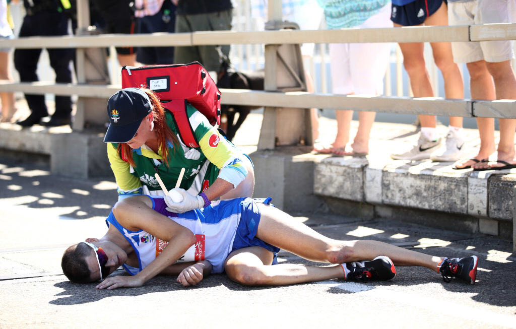 Callum Hawkins of Scotland is given assistance as he collapses in the Men's marathon.