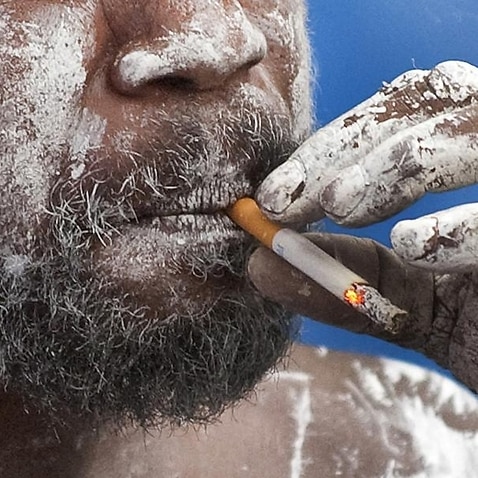 An Aboriginal man smokes a cigarette