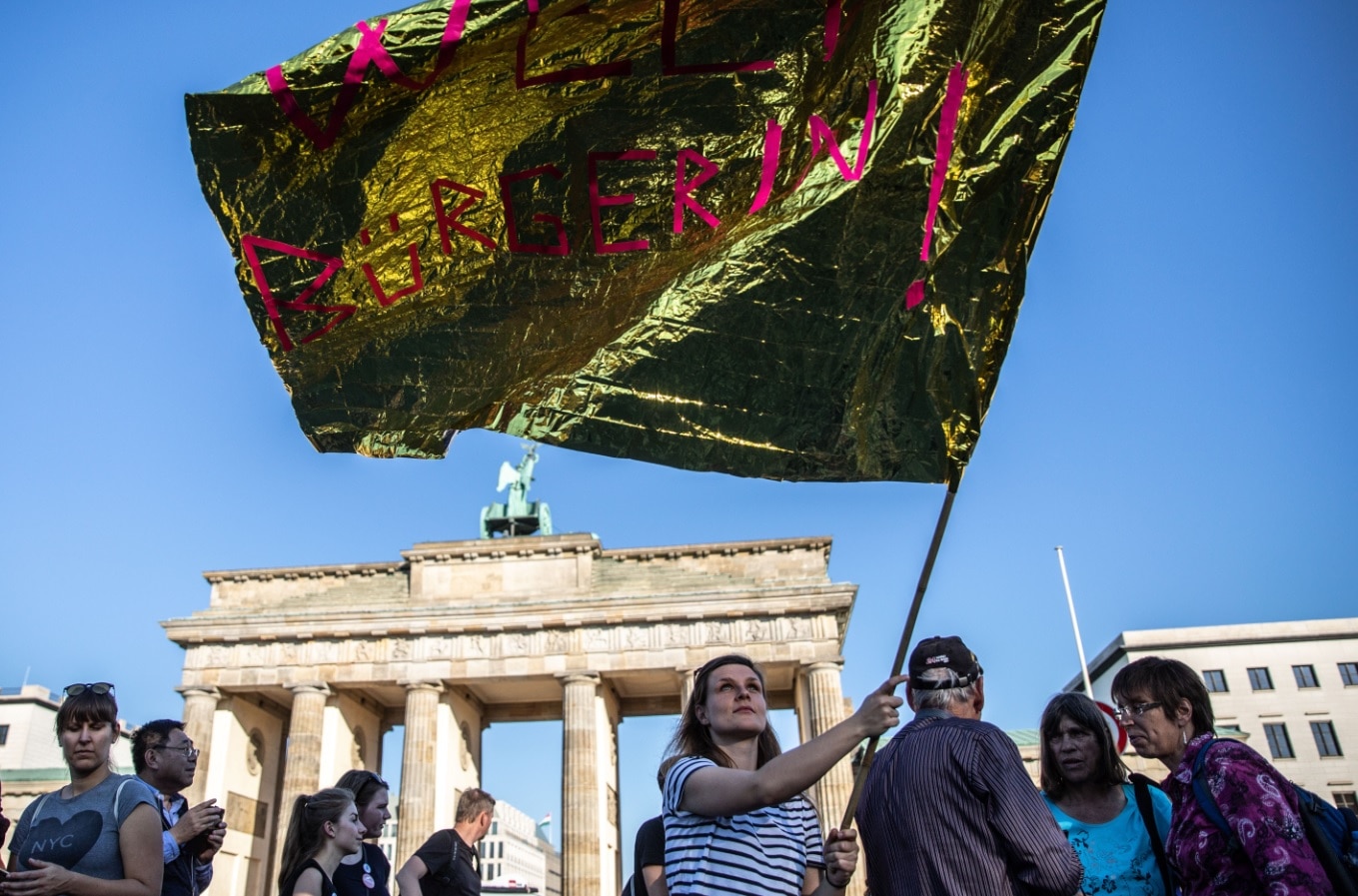 A demonstrator waves a flag , during a mass protest under the title '#unteilbar' in Berlin, A demonstrator waves a flag , during a mass protest under the title '#unteilbar' in Berlin,