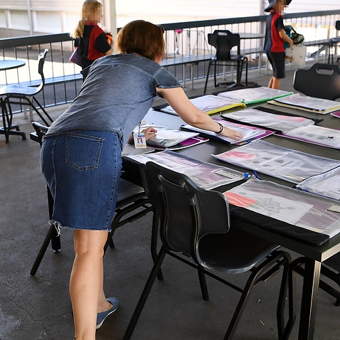 A teacher prepares a take-home activity packs at a primary school in Brisbane