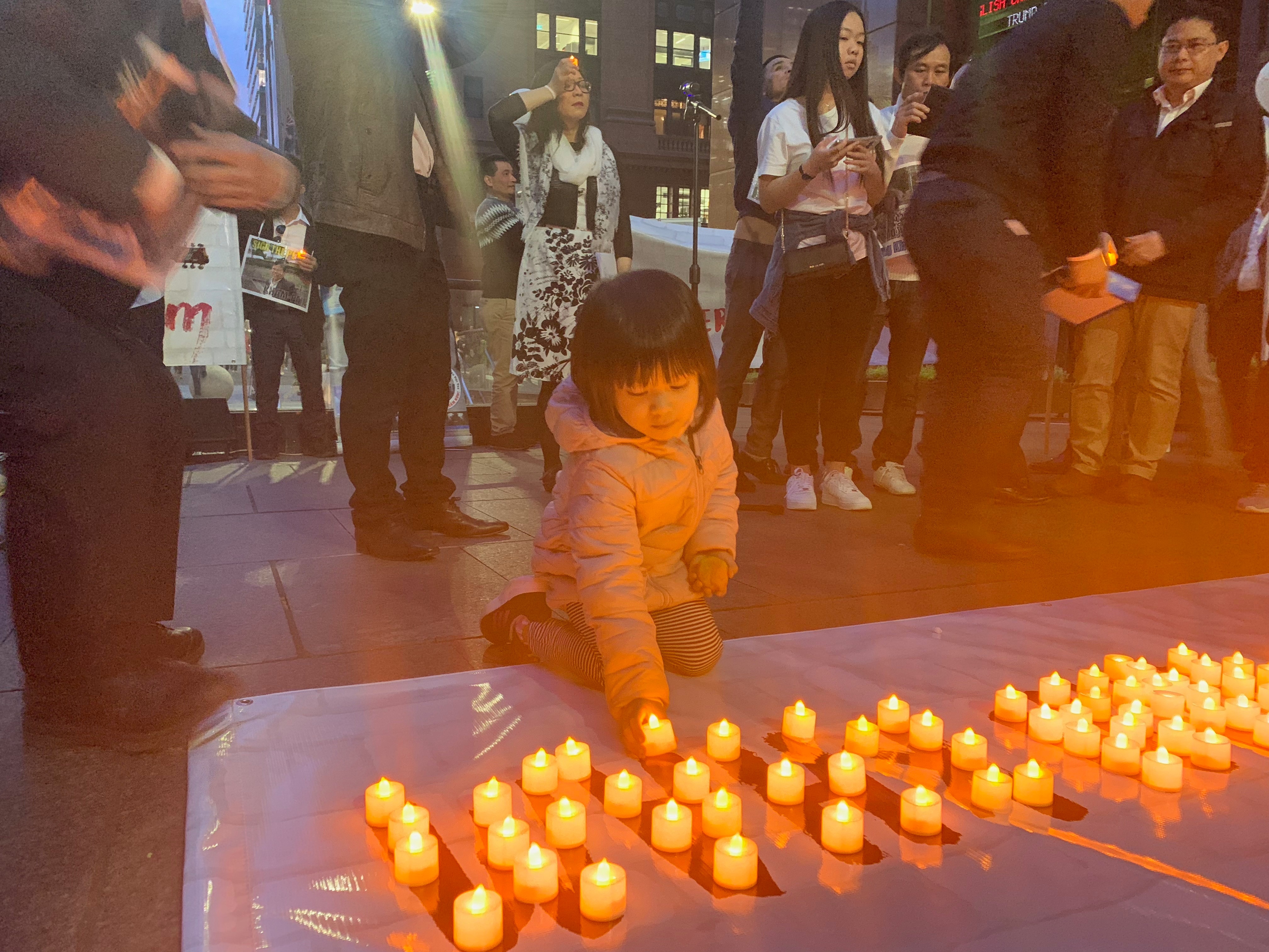 Supporters of Mr Chau light a candle in solidarity in Sydney's Martin Place. 