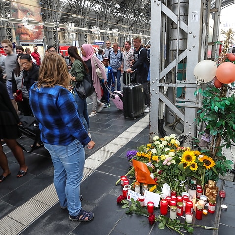 People put flowers near the place where a child was pushed onto the tracks in Frankfurt's central station (Hauptbahnhof), Germany.