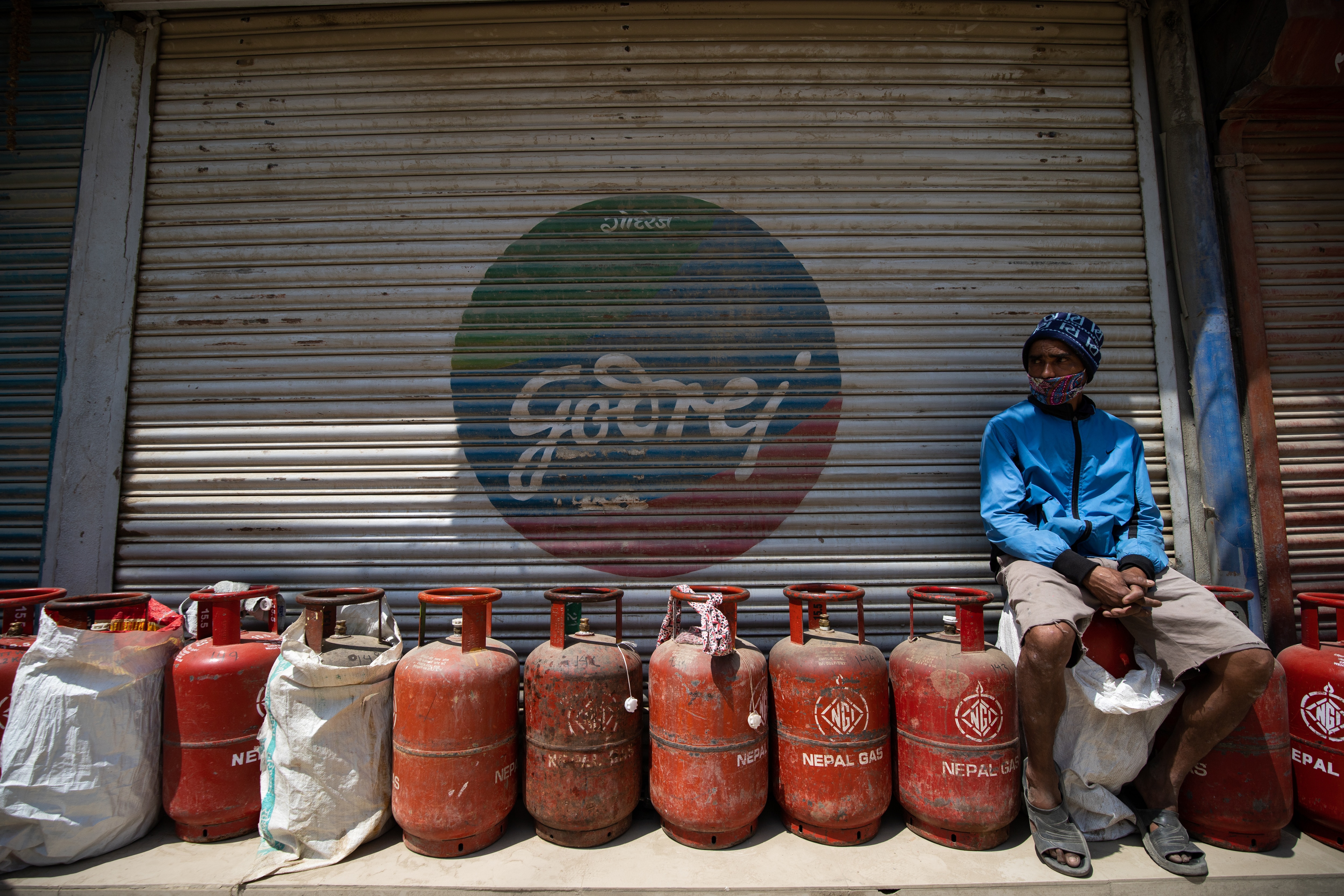 A man wearing a face mask as a preventive measure, seats on LPG cylinders as he waits in a queue, during the ninth day of the nationwide lockdown..Amid concerns about the spread of corona virus (COVID-19), the government of Nepal has extended the nationwi