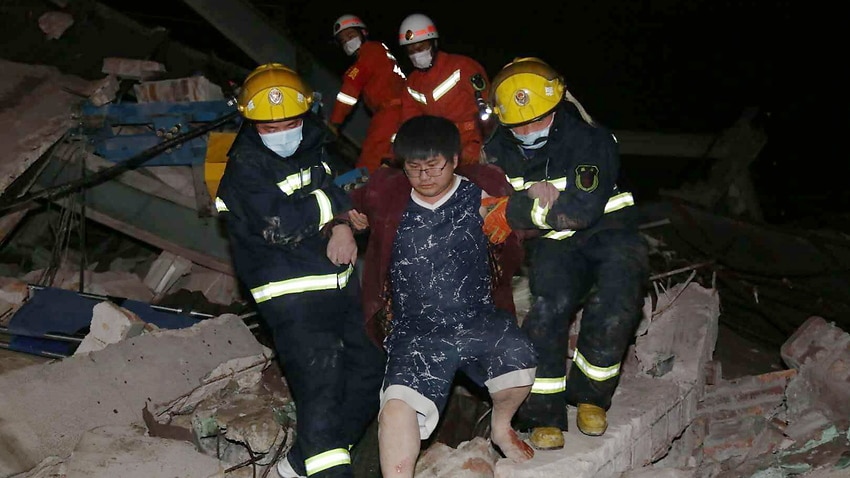 Rescuers carry out an injured man from the rubbles of a collapsed five-story hotel building in Quanzhou.
