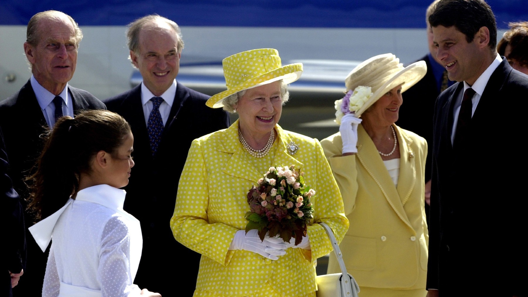 23 March 2000. Queen Elizabeth II arrives in Melbourne for the first time in twelve years and is gifted with flowers by Amy Bracks in white. Also pictured (left to right) is Duke of Edinburgh, Prince Philip, Victorian Governer Sir James Gobbo, Lady Gobbo 