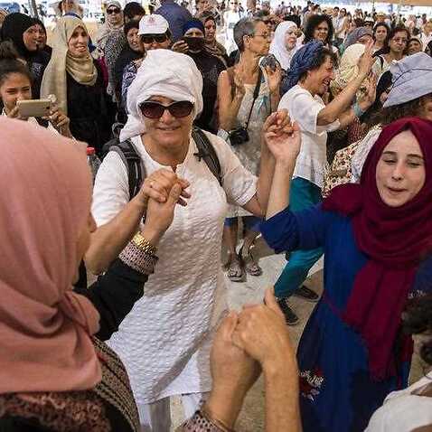 Israeli and Palestinian women dance together under a large tent during a mass protest and a march in the desert near Beit HaArava in the Jordan Valley, Israel