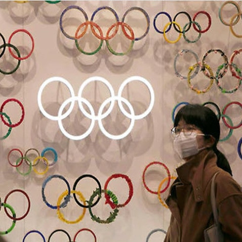 Two people wear masks as they visit the newly opened Japan Olympic Museum