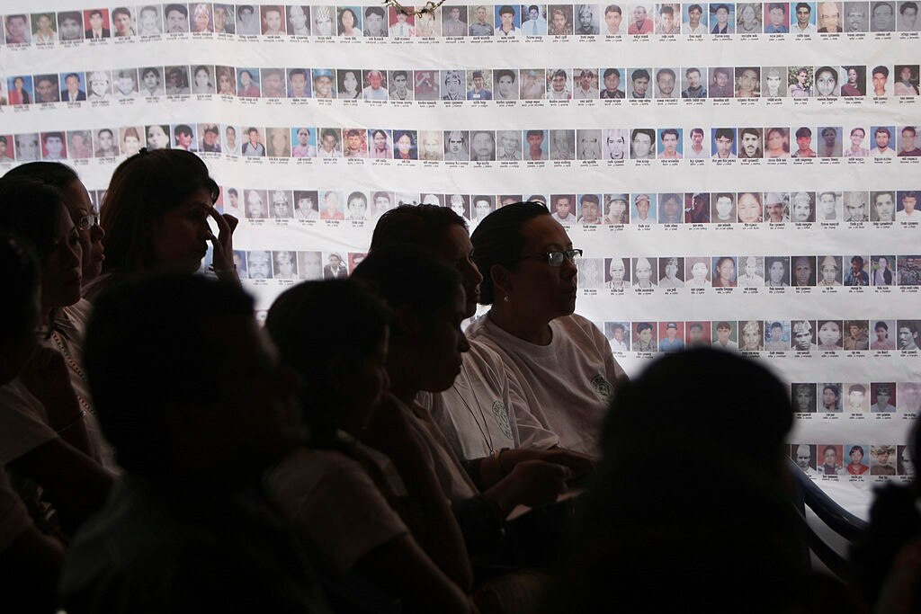 Attendees gather in front of photographs of missing after Nepal conflict.