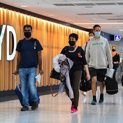Passengers arrive from their overseas flights and walk to the arrivals hall after landing at Sydney Airport