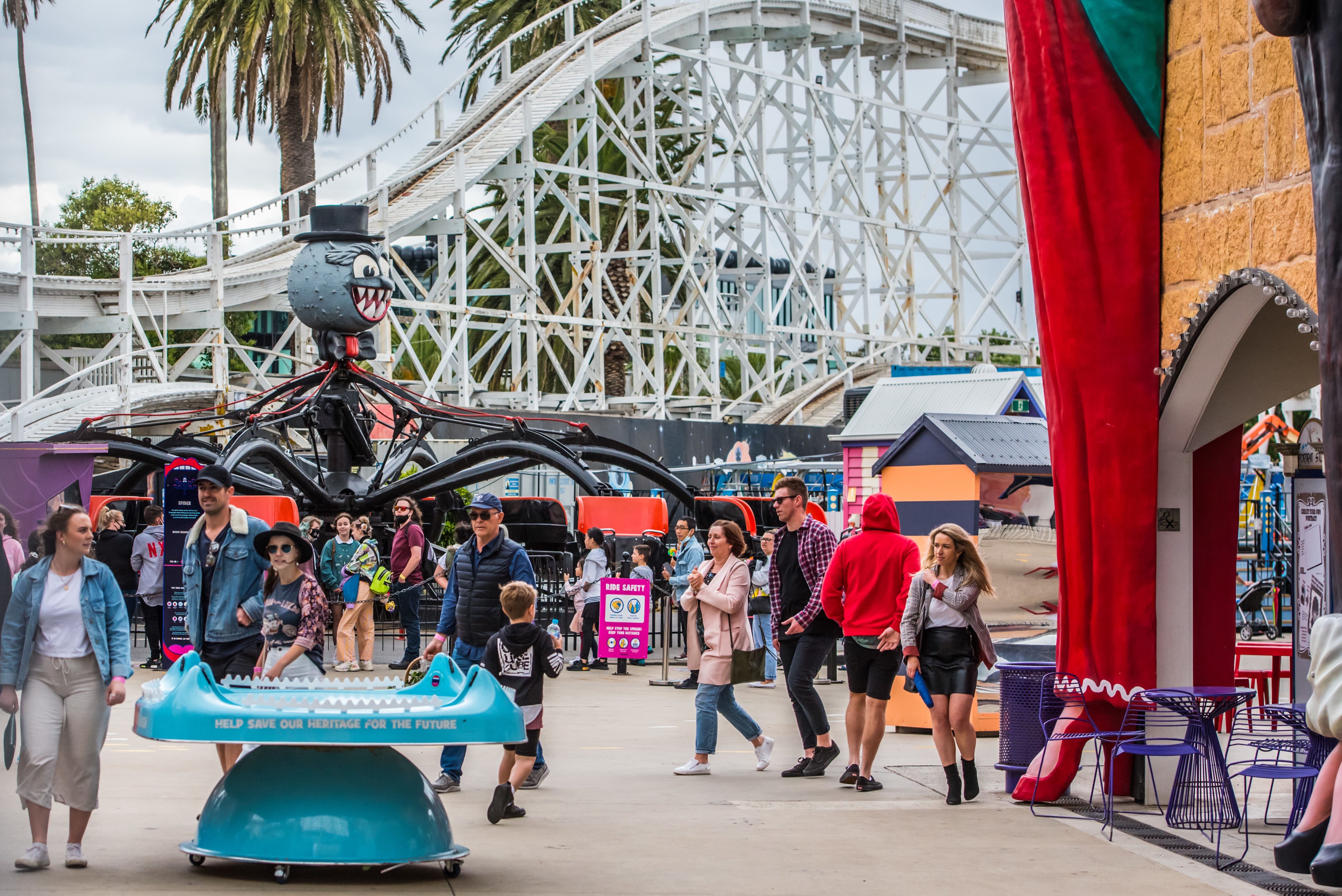 People seen walking around and lining up for rides without wearing masks at Luna Park in Melbourne.