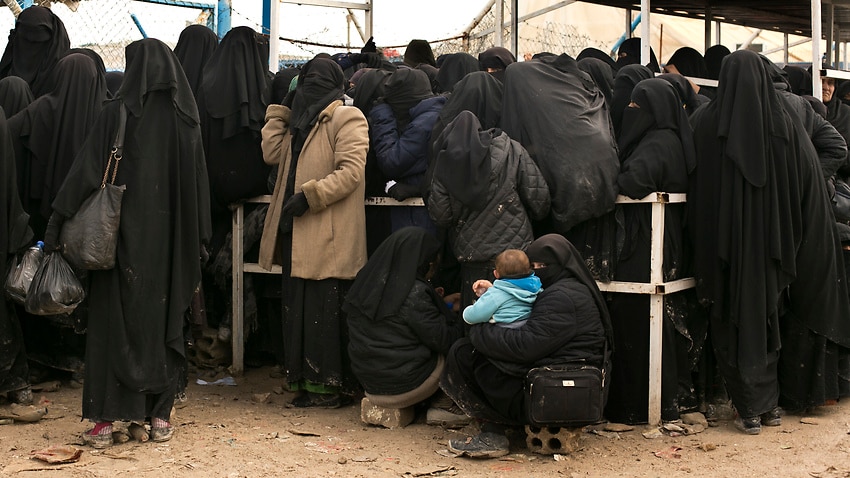 Women residents from former IS-held areas in Syria line up for aid supplies at Al-Hol camp in Hassakeh province, Syria.