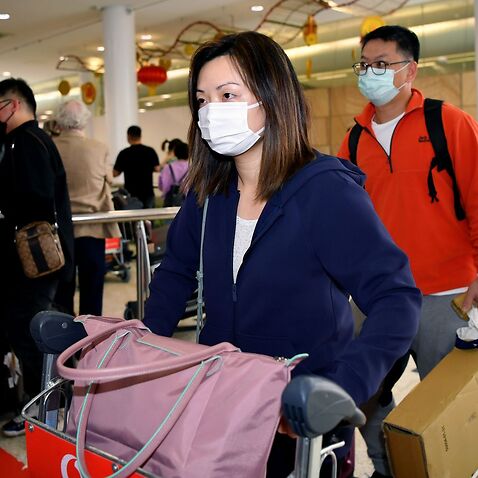 Passengers wearing a protective masks on arrival at Sydney International Airport in Sydney.