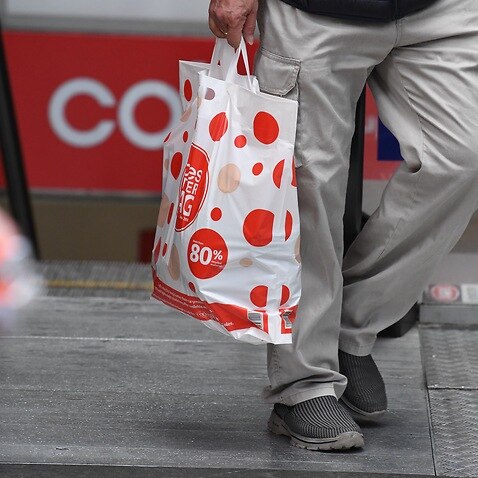 A shopper is seen carrying a reusable plastic bag at a Coles Sydney CBD store, Sydney, Monday, July 2, 2018. Woolworths says it will hand out free reusable bags for the next 10 days as its customers get used to its ban on single-use plastic bags. Woolies 