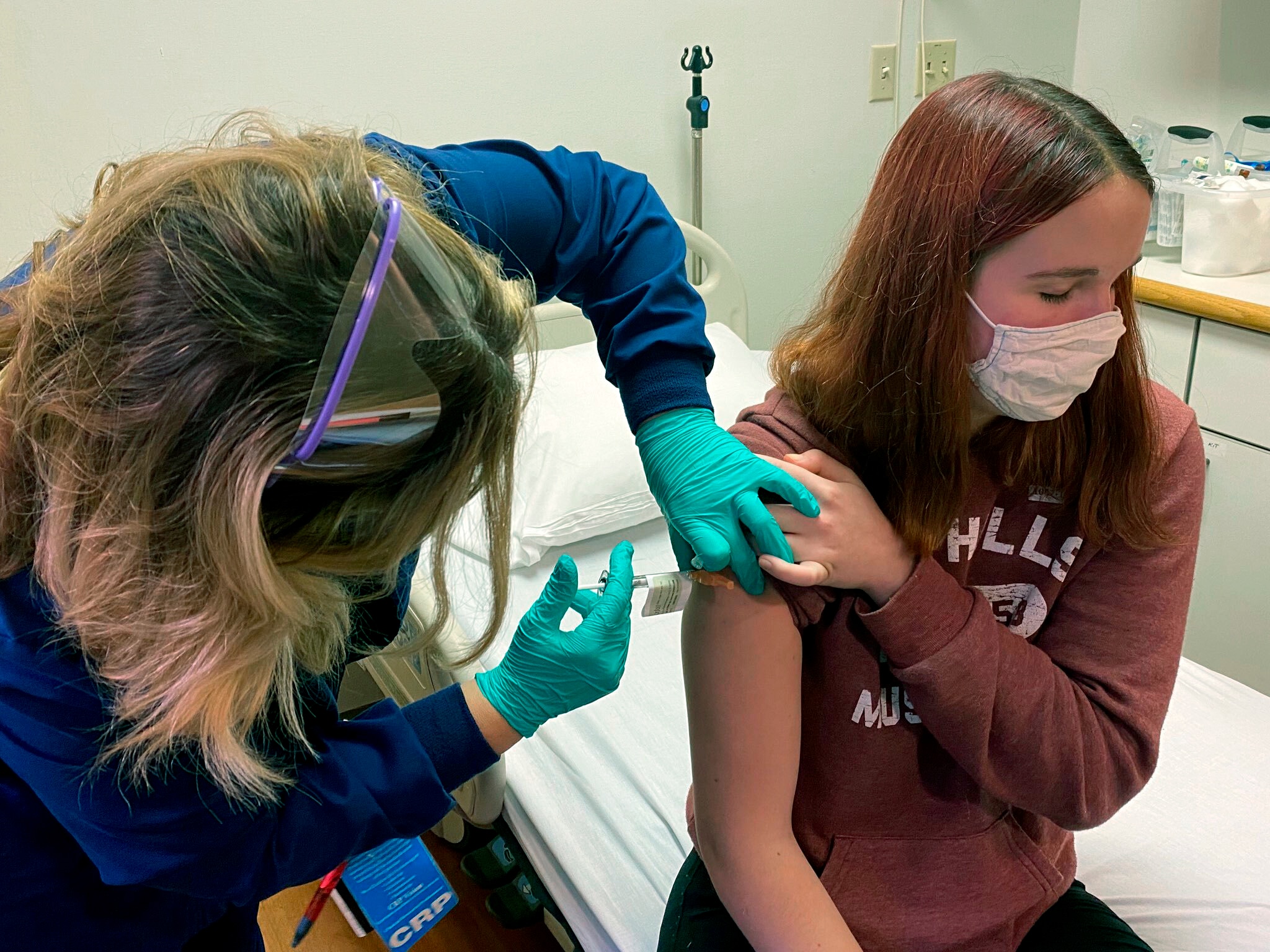 يدير منسق أبحاث حقنة لكاتلين إيفانز كجزء من تجربة سريرية للقاح فايزر COVID-19 في مستشفى سينسيناتي للأطفال.