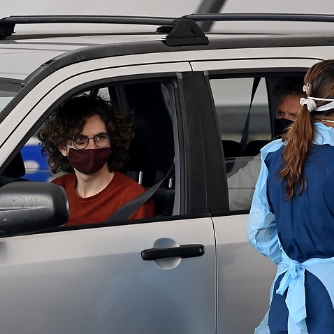 Members of the public queue in their cars for a COVID-19 PCR test in Sydney.