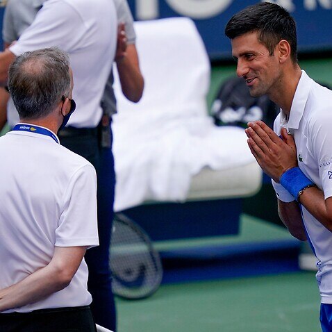 Novak Djokovic talks with the umpire after inadvertently hitting a line judge with a ball during the match against Pablo Carreno Busta at the 2020 US Open tennis championships