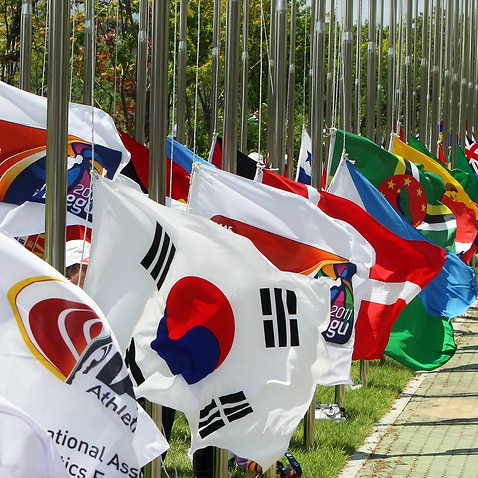 Volunteers hoist national flags at the Athletes' Village for the 2011 IAAF World Championships in Daegu on Aug. 5. (AAP Image/Yonhap News Agency)